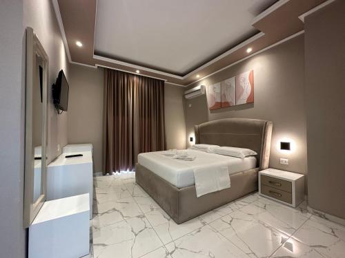 a bedroom with a bed and a television in it at Perseus Hotel in Palasë