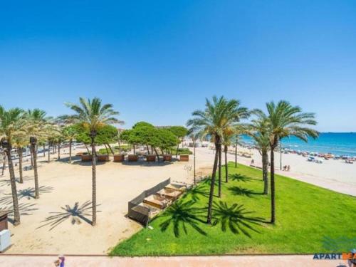 a view of a beach with palm trees and the ocean at APARTBEACH EUROPEOS JUNTO PLAYA CLIMATIZADO CON GRAN TERRAZA y MUY LUMINOSO in La Pineda