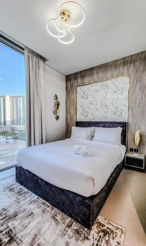 a bedroom with a large bed and a large window at STAY BY LATINEM Luxury 2BR Holiday Home CV B601 near Burj Khalifa in Dubai