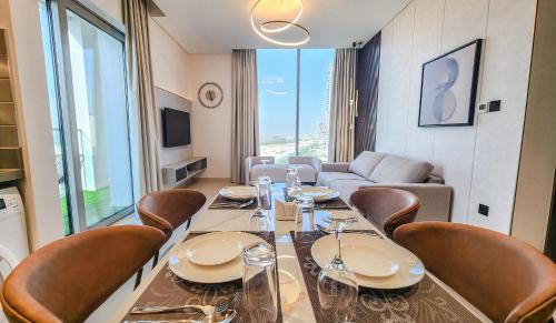 a dining room with a long table and chairs at STAY BY LATINEM Luxury 2BR Holiday Home CV B601 near Burj Khalifa in Dubai