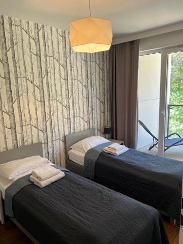 una camera d'albergo con due letti e una finestra di Sosnowe Apartamenty - Marina 3 a Augustów