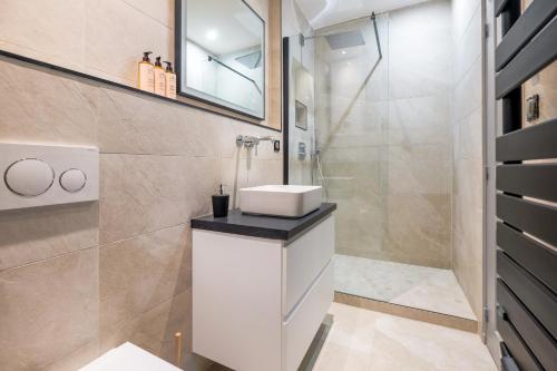 une salle de bain avec un lavabo et une douche dans l'établissement HONORÊ SUITE VUE SAONE, à Lyon