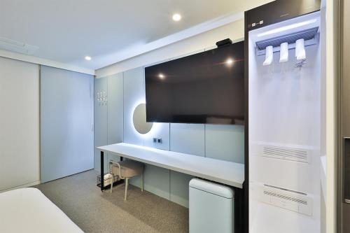Habitación con cama, escritorio y TV. en DOAN STAY HOTEL, en Ulsan