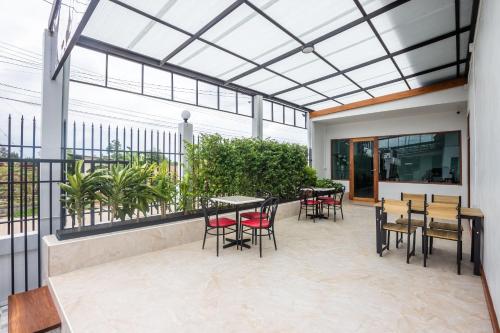 eine Terrasse mit Tischen und Stühlen und einer Glasdecke in der Unterkunft Tonsoi Hathairat in Ban Tao Pun