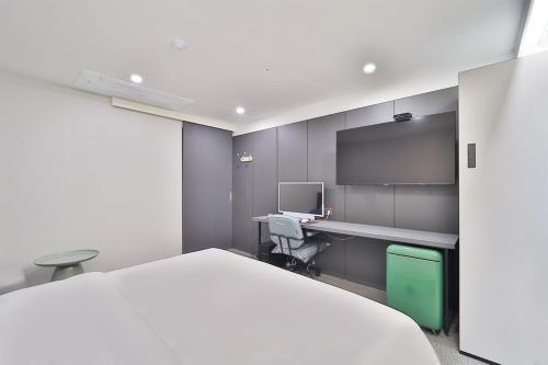 1 dormitorio con cama, escritorio y ordenador en DOAN STAY HOTEL en Ulsan