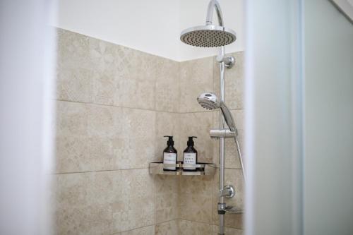 a shower with two bottles on a shelf in a bathroom at Ugento Country Cottage - Villa con Piscina in Ugento