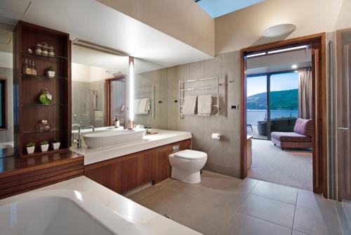 a bathroom with a tub and a sink and a toilet at Yacht Club 33 Serenity House Ocean Views 2 Buggies in Hamilton Island
