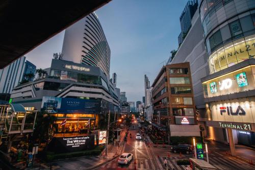 The Westin Grande Sukhumvit, Bangkok في بانكوك: شارع المدينة مزدحم بالمباني والسيارات في الشارع
