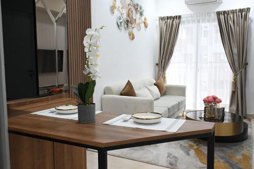 a living room with a table and a couch at Apartment Medan Podomoro City Deli by OLS Studio in Medan