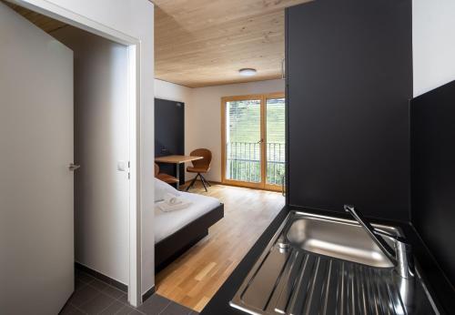 a kitchen with a sink and a bed in a room at Simotel in Aussersiggam