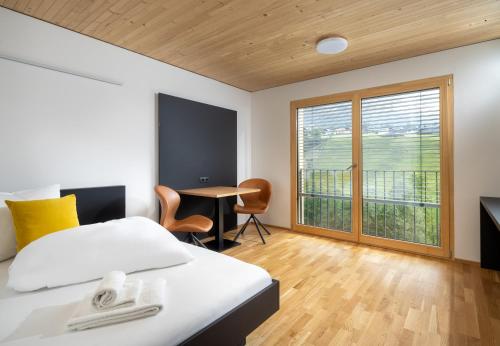 een slaapkamer met een bed, een bureau en een raam bij Simotel in Aussersiggam