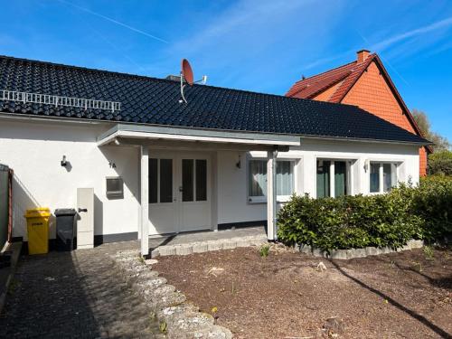 una casa blanca con techo negro en EICstay - Ferienhaus für Monteure und Familie, en Worbis