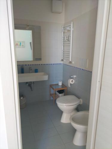 a bathroom with two toilets and a sink at Maison De Revel in Civitavecchia