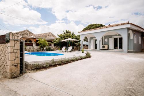 an exterior view of a house with a swimming pool at Rahes Villa with Private Pool in Zakynthos Town