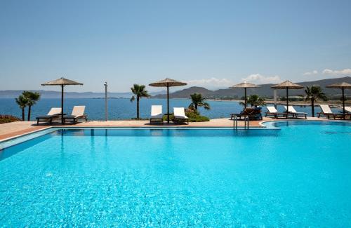 a large blue swimming pool with chairs and umbrellas at Balos Beach in Kissamos