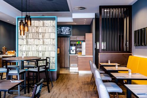 a restaurant with tables and chairs and a counter at Premier Inn Nürnberg City Centre in Nürnberg