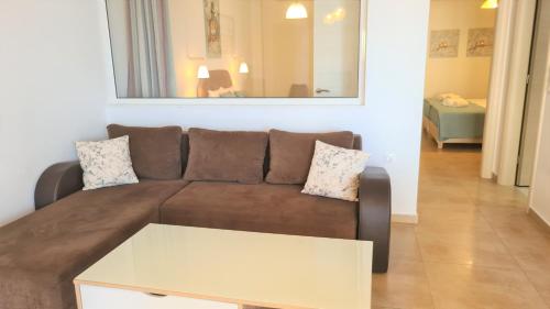 a living room with a brown couch and a table at Bella Mare Luxury Apartments in Kalamaki Heraklion