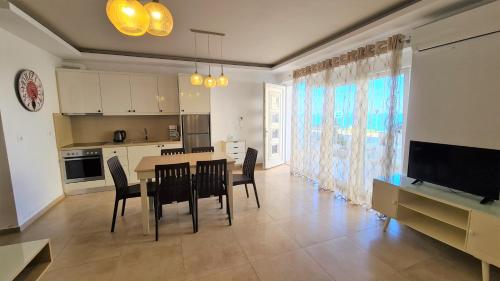 a kitchen and dining room with a table and chairs at Bella Mare Luxury Apartments in Kalamaki Heraklion