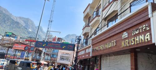 a busy street in a city with buildings and people at Hotel Krishna in Katra