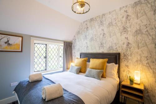 - une chambre avec un grand lit et des oreillers jaunes dans l'établissement Kettleburgh Chequers, à Kettleburgh