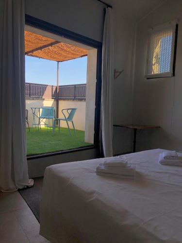 une chambre avec un lit et une fenêtre avec vue dans l'établissement Apparts Et Lofts Bistrot Des Alpilles, à Saint-Rémy-de-Provence