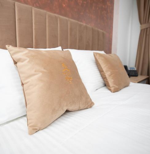 a white bed with two pillows on top of it at Hotel Del Ponte in Târgovişte