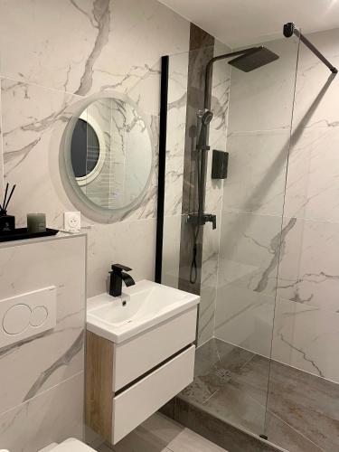 a white bathroom with a sink and a shower at Appartement avec jacuzzi in Sassenage