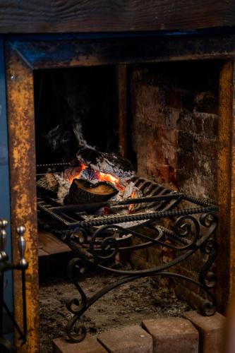 a fire in a fireplace with some food in it at Kettleburgh Chequers in Kettleburgh