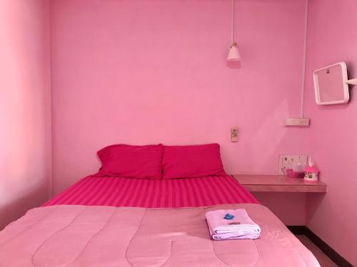 ein rosafarbenes Schlafzimmer mit einem Bett mit einer rosa Wand in der Unterkunft แสงสง่ารีสอร์ท Saeng Sa-Nga Resort 