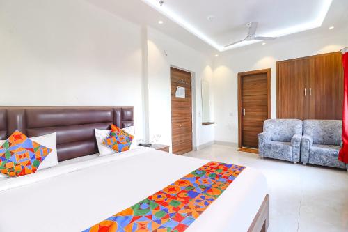 a hotel room with a bed and a chair at FabHotel Bhawana in Agra