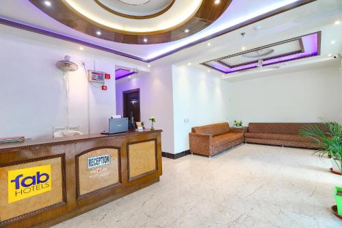 a lobby of a hotel with a tv and a couch at FabHotel Bhawana in Agra