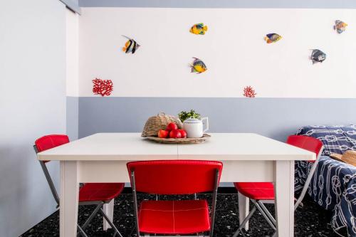 een eetkamer met een witte tafel en rode stoelen bij Raffaello House in Sestri Levante