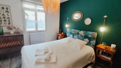 康村的住宿－Oasis de tranquiillité，一间卧室设有一张白色大床和绿色的墙壁