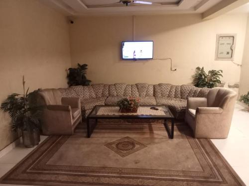 a living room with a couch and a tv at Hotel Seven Eleven in Lahore