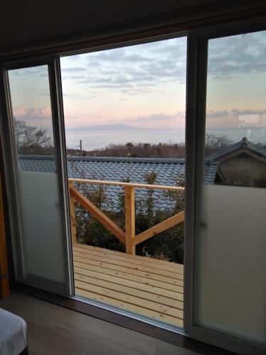 a room with a window with a view of the water at JOYinn in Ito