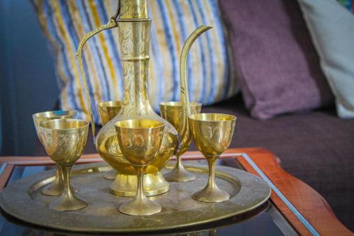 uma bandeja com quatro taças de vinho e um vaso sobre uma mesa em The Marrakech Style Loft Apartment em Carstairs