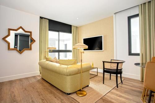 a living room with a couch and a table at Genteel Home Betis 67 in Seville