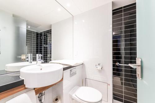 a white bathroom with a toilet and a sink at Premier Inn Nürnberg City Centre in Nürnberg