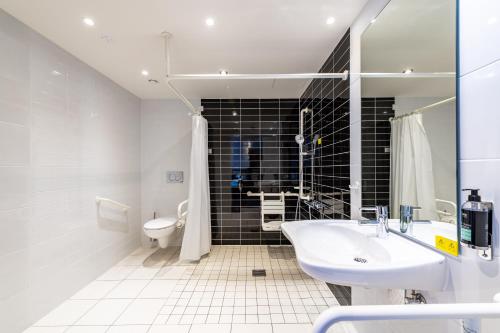 a bathroom with a white sink and a toilet at Premier Inn Nürnberg City Centre in Nuremberg