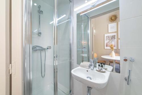 uma casa de banho com um chuveiro, um lavatório e um espelho. em 2 pièces dans le centre de Beaulieu-sur-Mer , proche de la mer em Beaulieu-sur-Mer