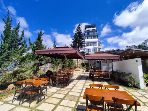 a patio with tables and chairs and a building at GREENECO DA LAT HOTEL - Khách sạn Green Eco Đà Lạt in Da Lat