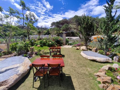 a group of tables and chairs in a garden at GREENECO DA LAT HOTEL - Khách sạn Green Eco Đà Lạt in Da Lat