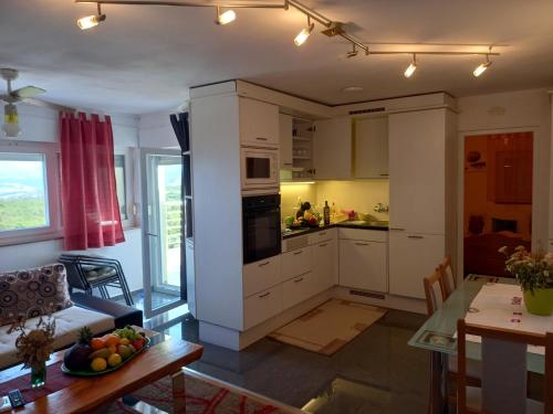 a kitchen and living room with a table and a dining room at D,apartman' ulica pušća 51, 51513 Omišalj in Omišalj