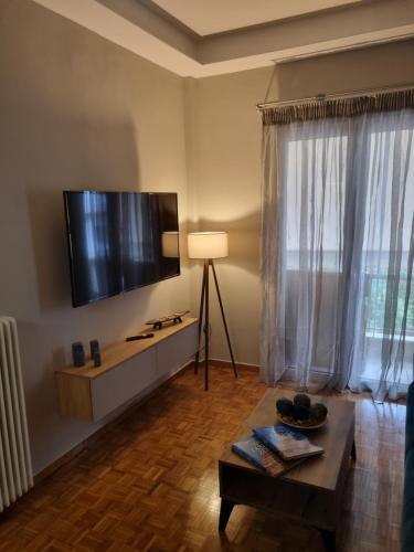 a living room with a flat screen tv on the wall at Piraeus open view Appartment in Piraeus