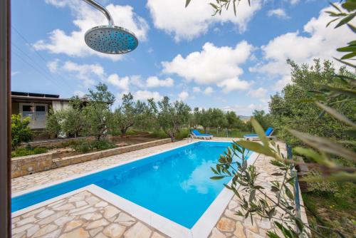a swimming pool in the backyard of a villa at Hakuna Matata Holidays wooden lodge with airco & pool in Greek Olive Grove in Methoni