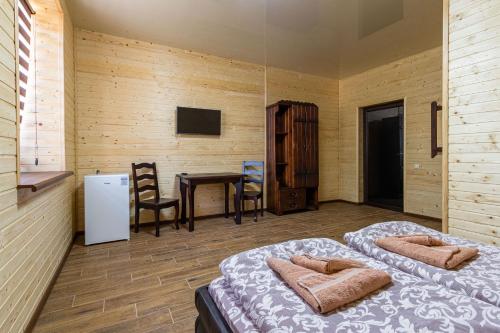 2 Betten in einem Zimmer mit Tisch und Stühlen in der Unterkunft Комплекс СільДар in Solotwyno