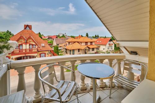 a balcony with a table and chairs and a view at Tokajer Wellness Panzió in Keszthely