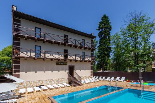 a villa with a swimming pool in front of a building at Комплекс СільДар in Solotvyno
