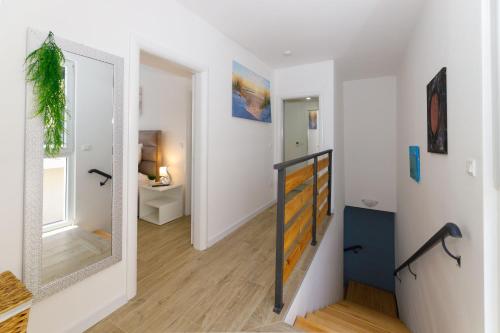 einen Flur mit einem Spiegel und eine Treppe mit einem Zimmer in der Unterkunft Villa Blue Lagoon in Makarska