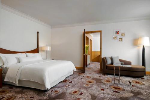 a bedroom with a large white bed and a couch at The Westin Grande Sukhumvit, Bangkok in Bangkok